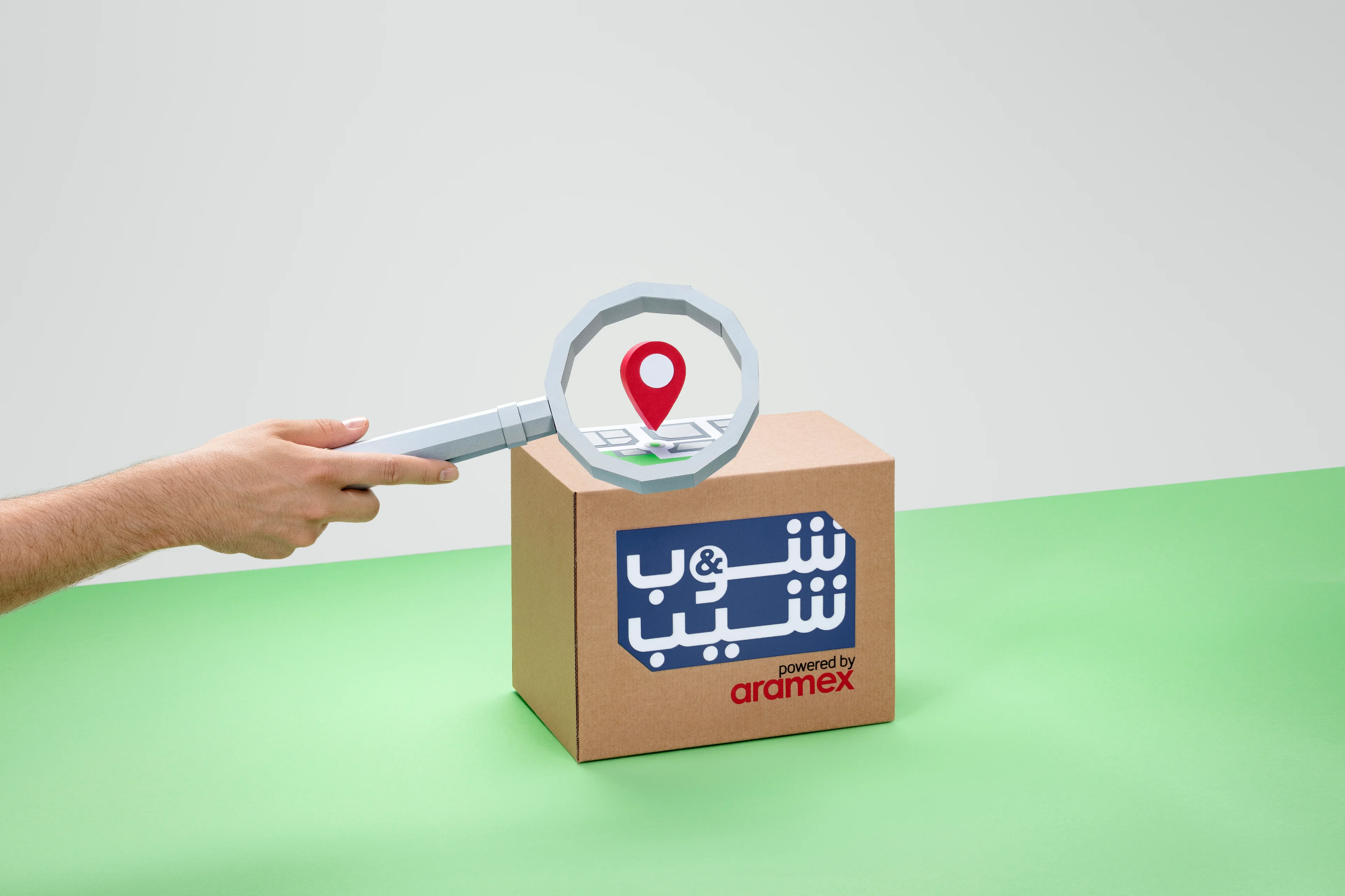 Shop & Ship paper-craft magnifying glass and package representing shipment tracking